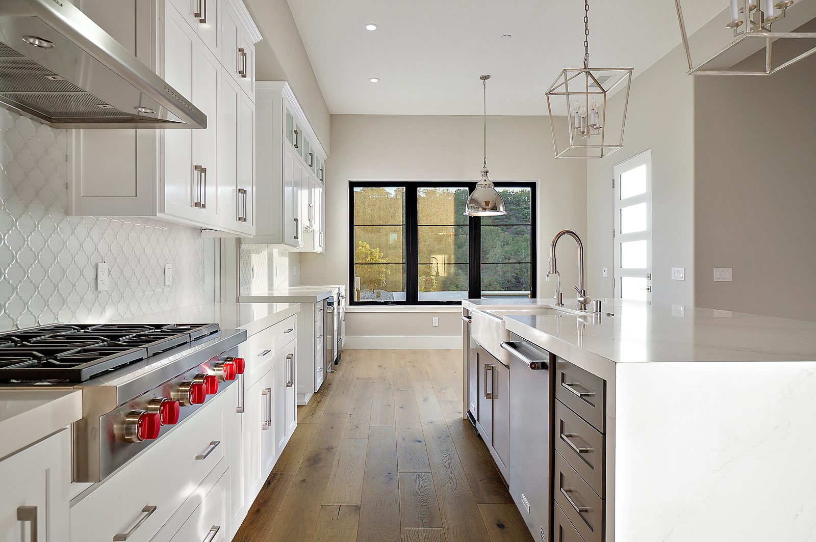 Kitchen with a professional gas range, full-height white tile backsplash and white cabinetry, Templeton