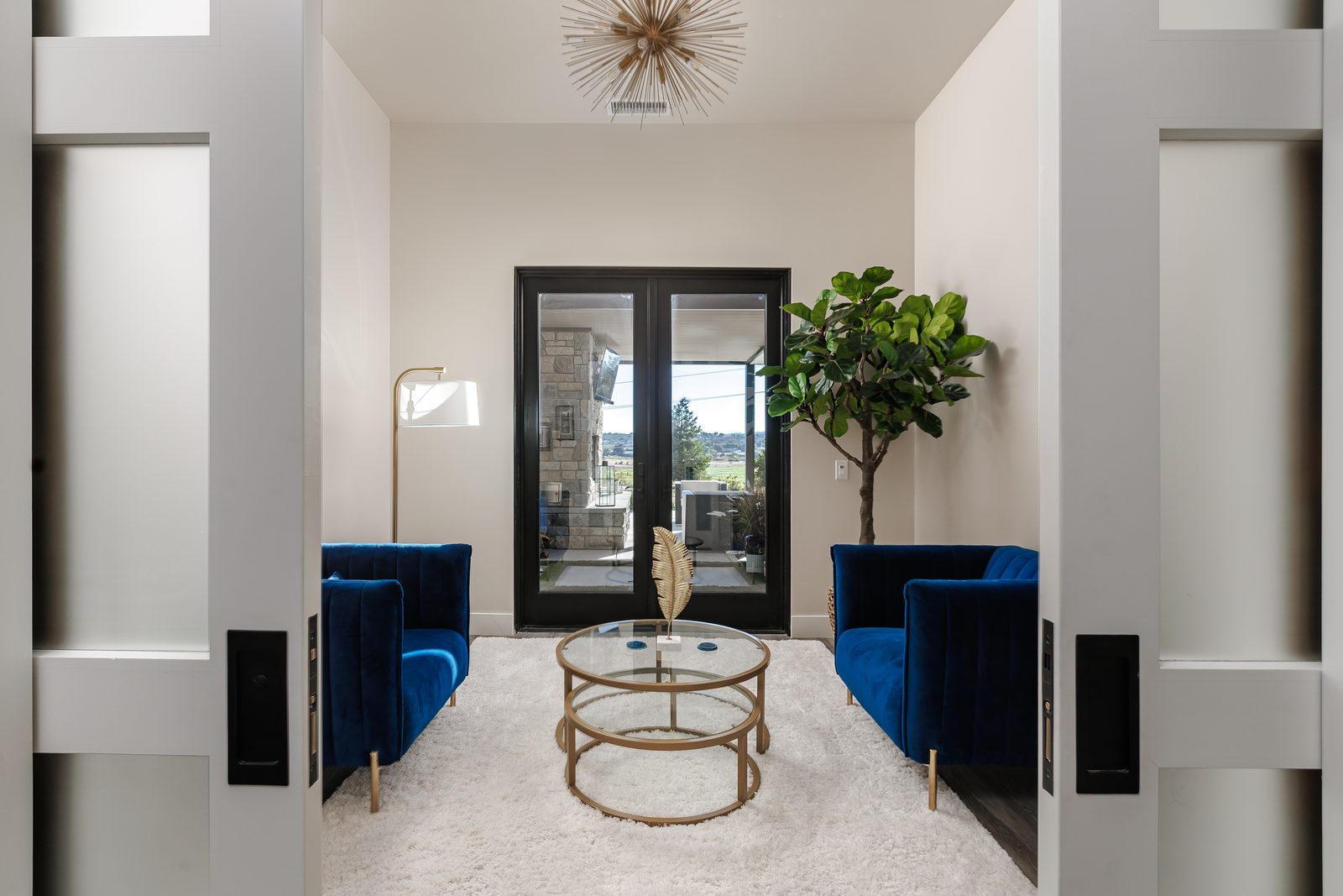 Entry foyer with black-framed glass double doors and a round glass table, Modern Ranch home in Templeton