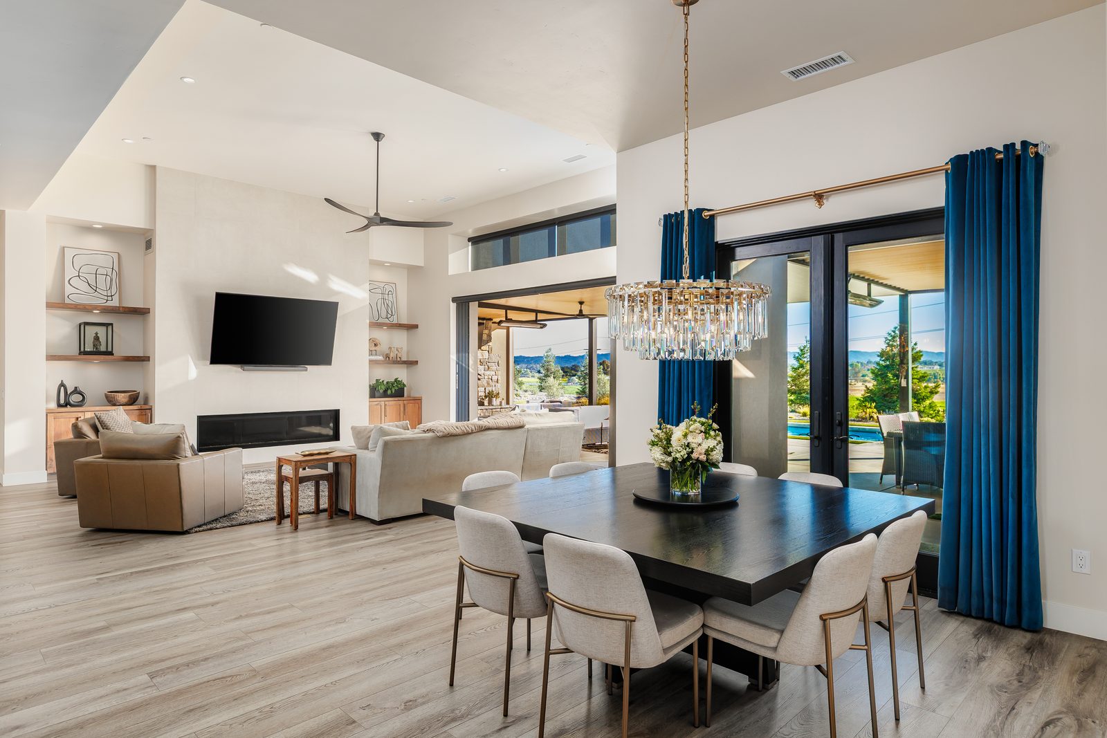 Open dining and living area with a linear fireplace and glass doors to the covered patio, Templeton