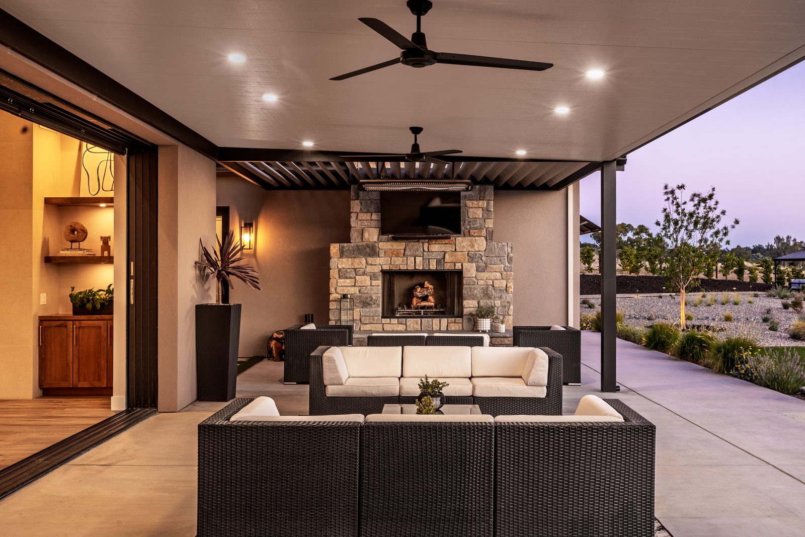 Covered outdoor room with a stone fireplace, ceiling fans and recessed lights, Modern Ranch in Templeton