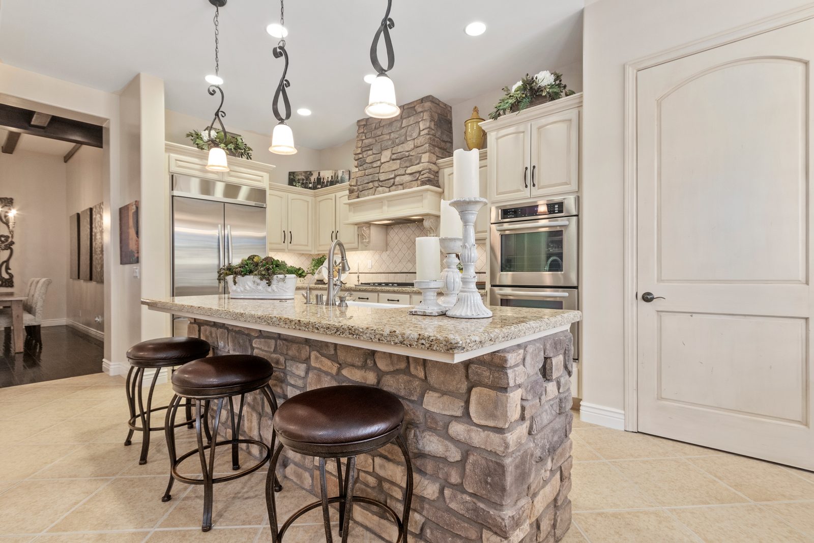 Kitchen with a stone-base island, granite counters, painted cabinets and pendant lights, Paso Robles