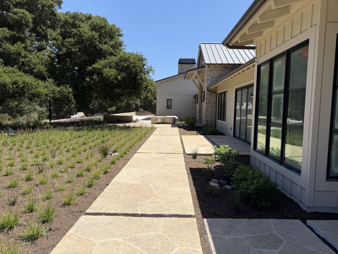 Flagstone walk and new meadow planting beside a custom home under construction, Santa Lucia Preserve